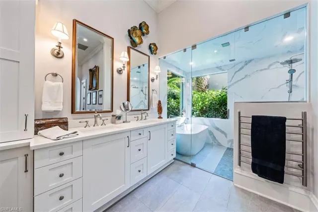 a spacious bathroom with a double vanity sink mirror and bathtub