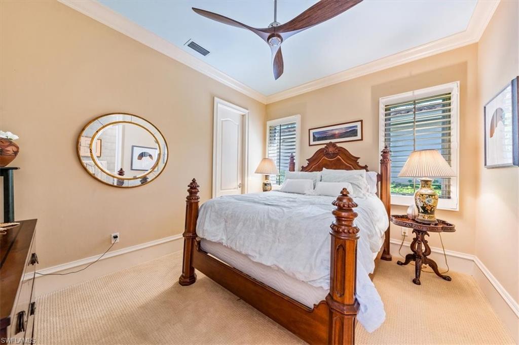 18051 Lagos Way Naples, FL 34110 - Photo 20 of 26 a bedroom with a bed and a mirror