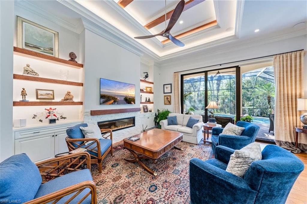 18051 Lagos Way Naples, FL 34110 - Photo 5 of 26 a living room with furniture fireplace and a large window