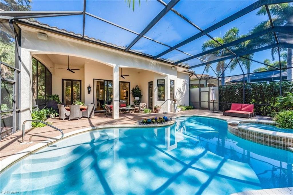 18051 Lagos Way Naples, FL 34110 - Photo 6 of 26 a view of a patio with table and chairs under an umbrella
