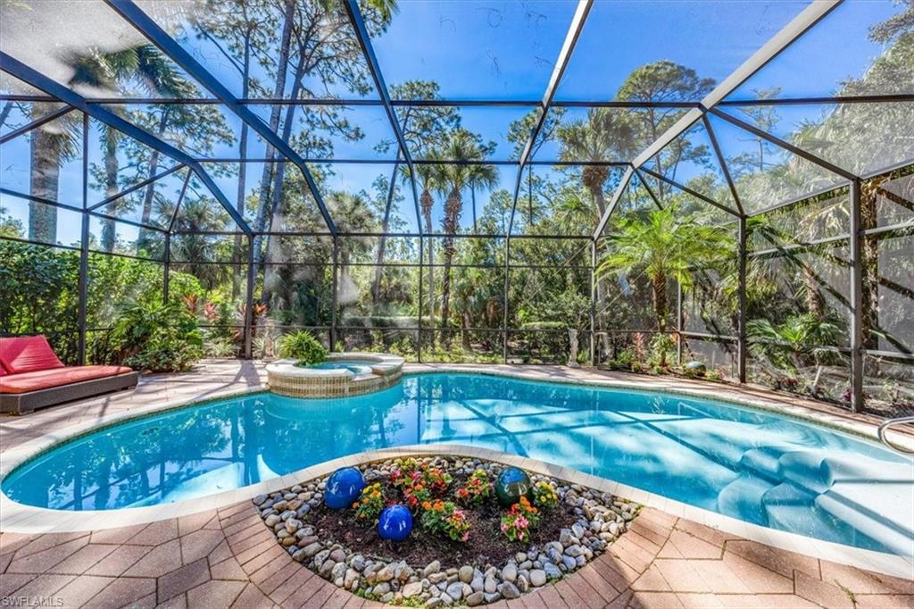 18051 Lagos Way Naples, FL 34110 - Photo 8 of 26 a view of a swimming pool with a patio