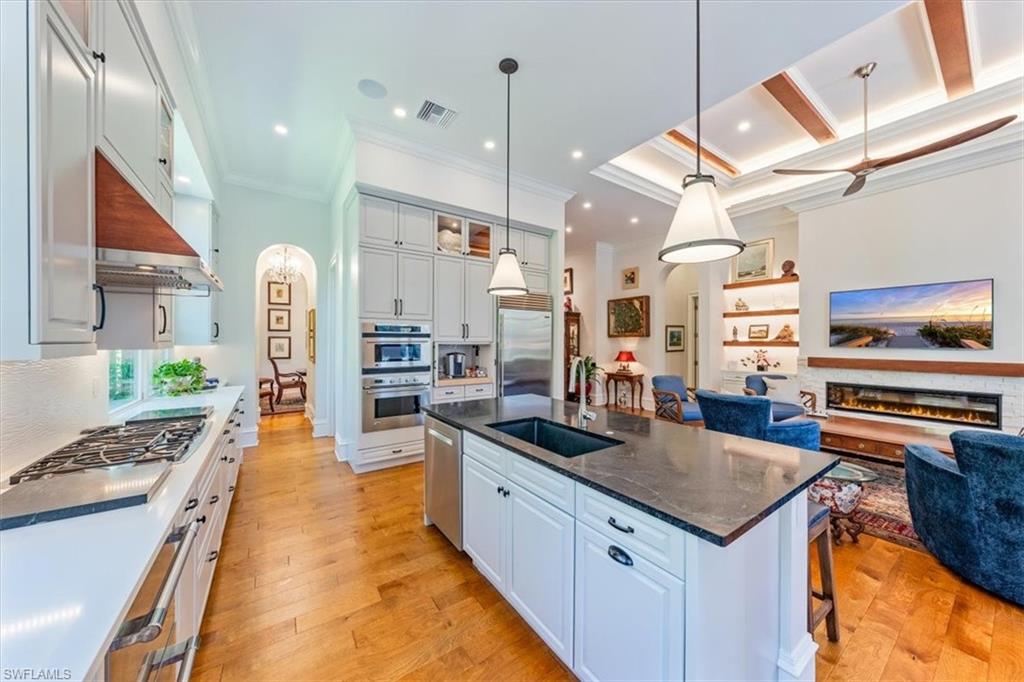 18051 Lagos Way Naples, FL 34110 - Photo 9 of 26 a kitchen with stainless steel appliances granite countertop a stove and a view of living room