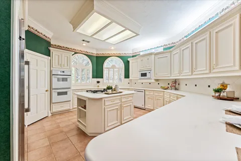 a kitchen with white cabinets and white appliances