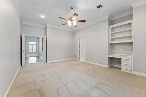 a view of an empty room with a fireplace and a ceiling fan