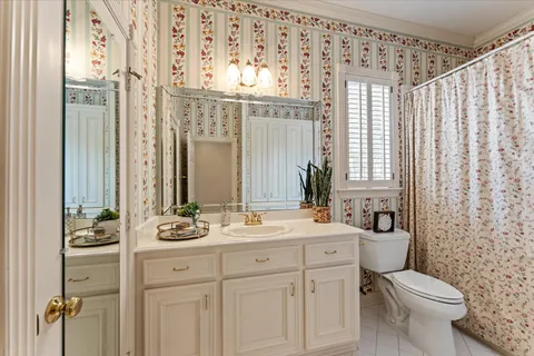 a bathroom with a double vanity sink toilet and shower
