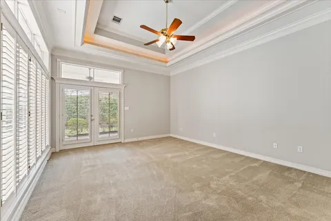an empty room with window and a ceiling fan