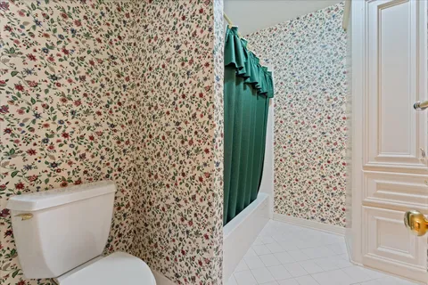 a bathroom with a toilet and a shower curtain