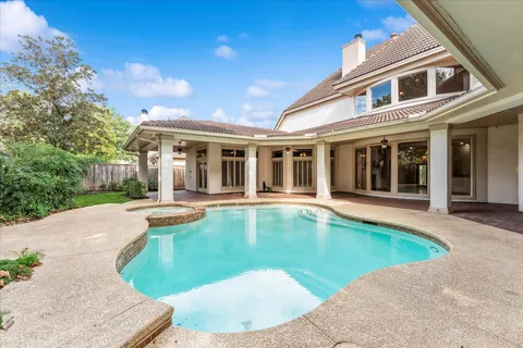 a view of a house with swimming pool and sitting area