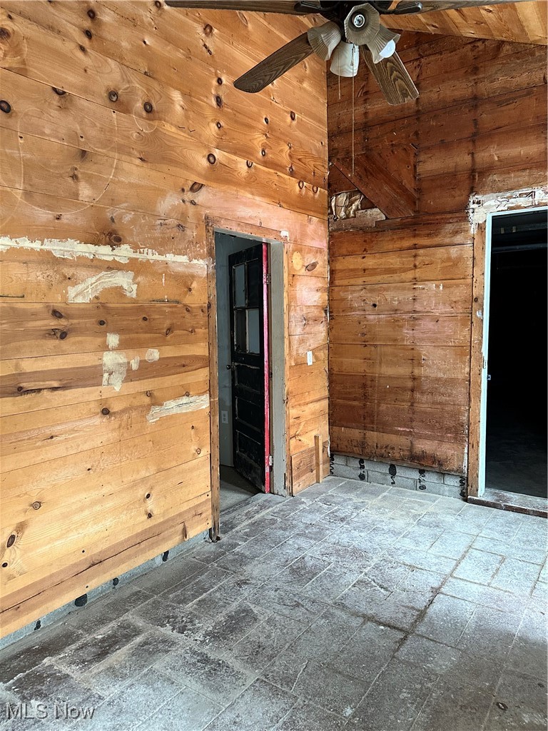 453 Lawn Street Geneva, OH 44041 - Photo 10 of 26 Unfurnished room with wooden walls, vaulted ceiling, and a ceiling fan