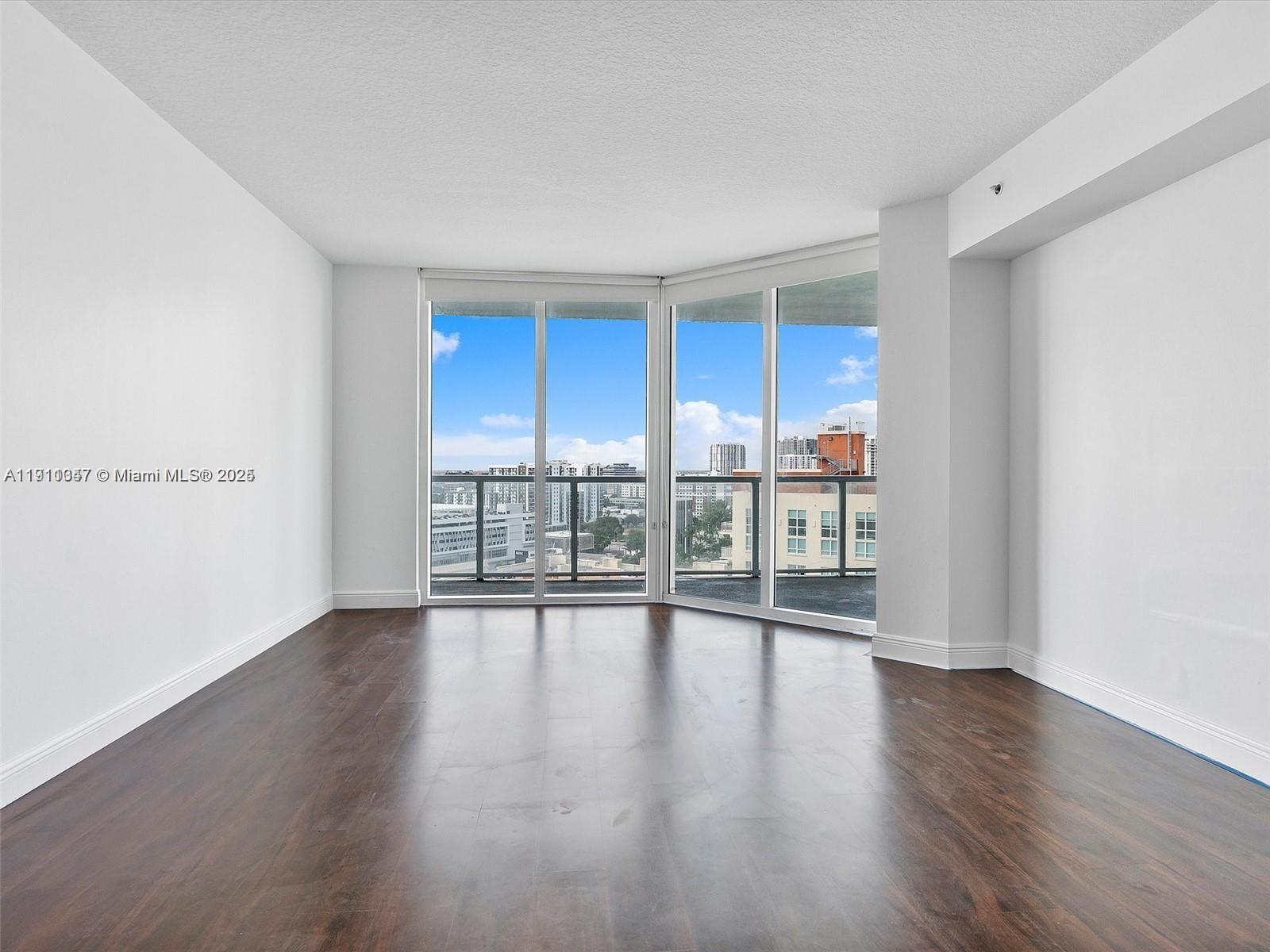 1900 North Bayshore Drive, Unit 1614 Miami, FL 33132 - Photo 5 of 15 a view of an empty room with wooden floor and a window