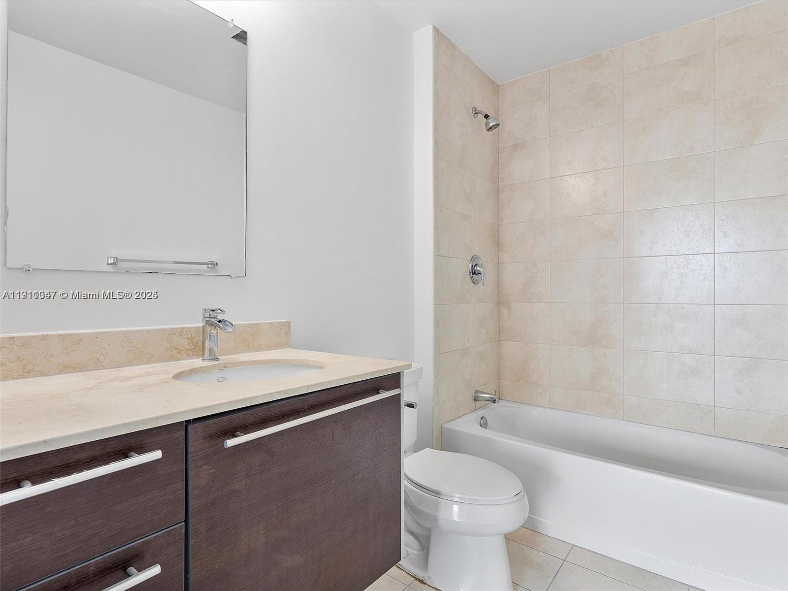1900 North Bayshore Drive, Unit 1614 Miami, FL 33132 - Photo 6 of 15 a bathroom with a granite countertop sink a toilet and shower