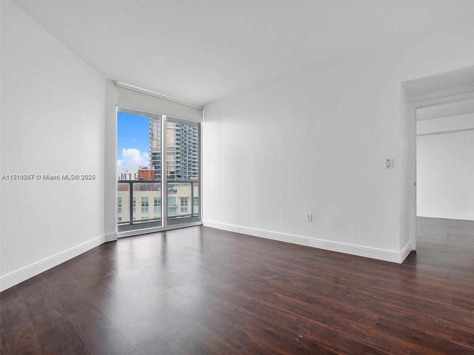 1900 North Bayshore Drive, Unit 1614 Miami, FL 33132 - Photo 7 of 15 a view of an empty room with wooden floor and a window