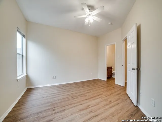 an empty room with wooden floor and window