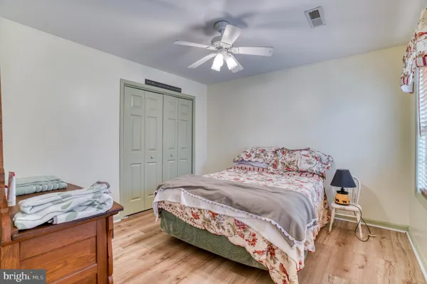 a room with a bench and a chandelier fan