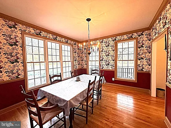 a kitchen with stainless steel appliances granite countertop a refrigerator a sink dishwasher a stove and a dining table with wooden floor