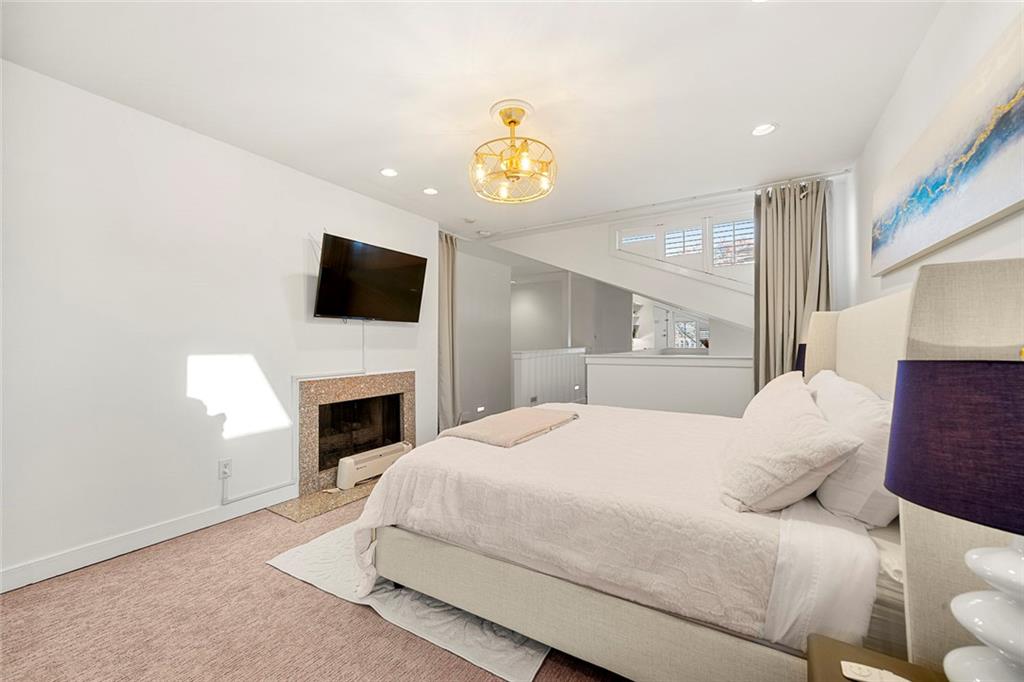2840 Peachtree Road Northwest, Unit 502 Atlanta, GA 30305 - Photo 17 of 27 a bedroom with a white bed and a fireplace