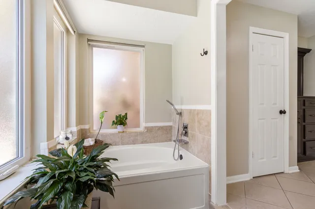 a bath room with a bathtub a sink and a window