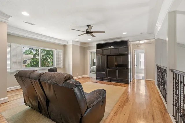 a living room with furniture a flat screen tv and a large window