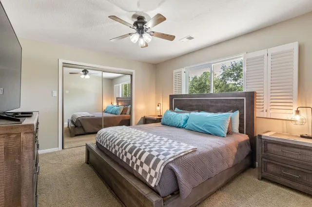 a bedroom with a large bed and a chandelier