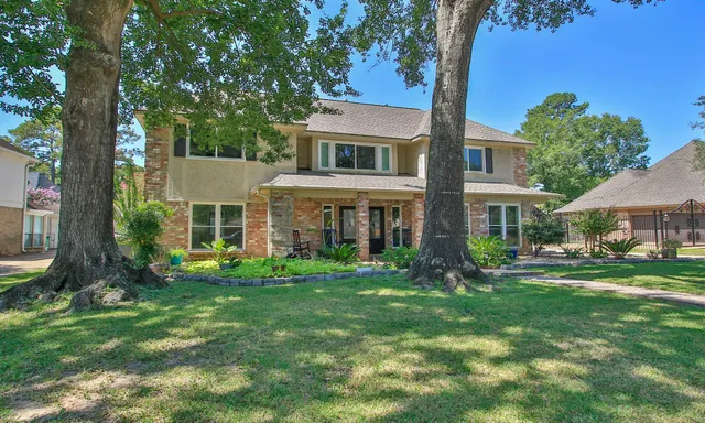 front view of a brick house with a yard