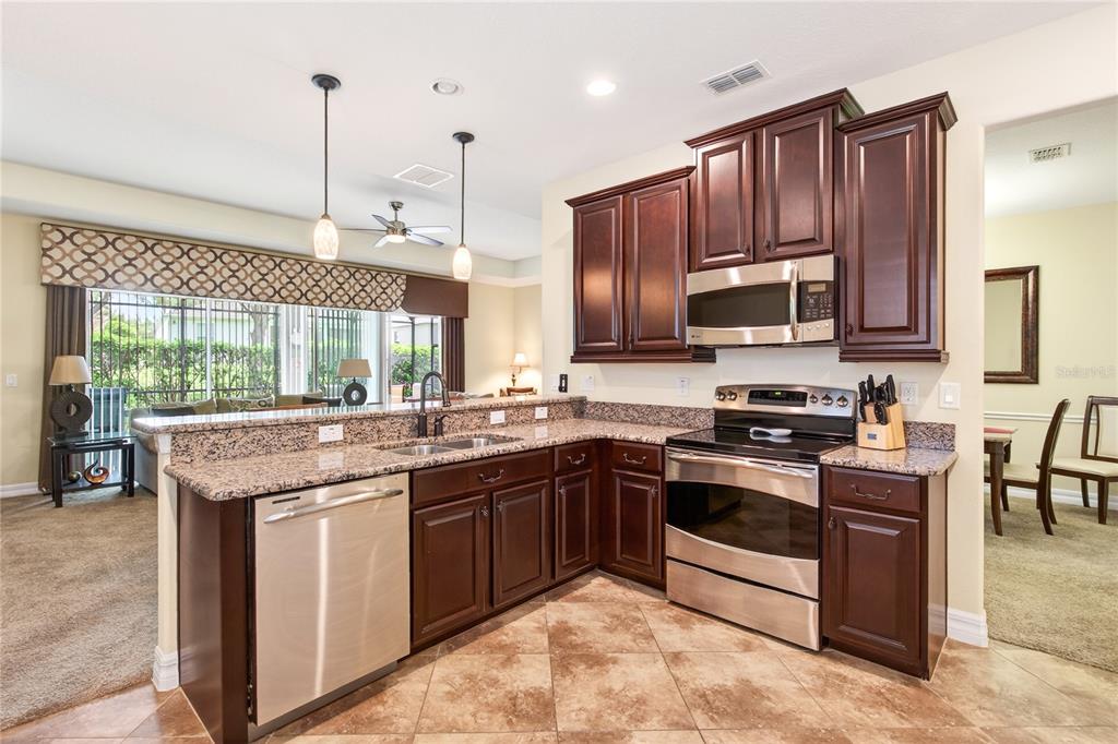 3651 Limestone Street Clermont, FL 34711 - Photo 5 of 41 a kitchen with stainless steel appliances granite countertop a stove a sink and a microwave