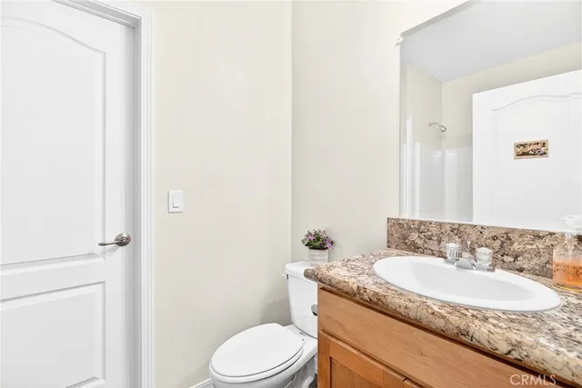 a bathroom with a granite countertop sink toilet and shower