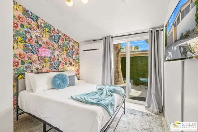 a bedroom with a bed and a painting on the wall