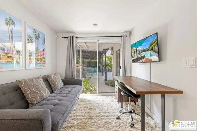 a living room with furniture and a floor to ceiling window