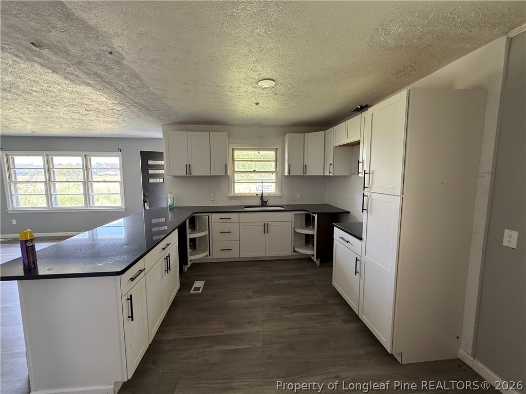 736 Tobermory Road Fayetteville, NC 28306 - Photo 14 of 17 a kitchen with stainless steel appliances granite countertop a refrigerator a sink dishwasher a stove and white countertops with wooden floor