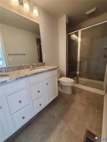 a bathroom with a double vanity sink toilet and shower