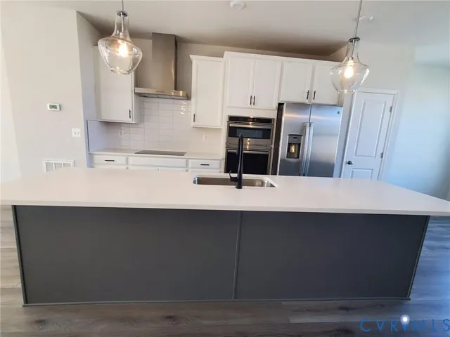 a kitchen with kitchen island sink and cabinets