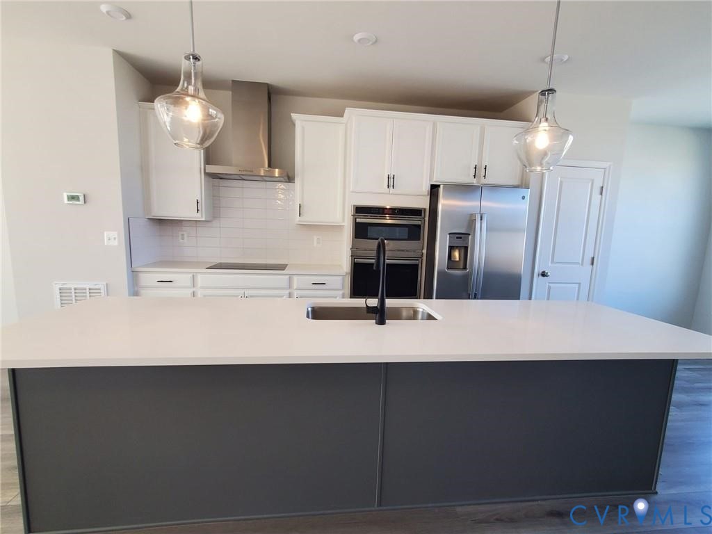 8833 Foxway Ridge Lane Glen Allen, VA 23060 - Photo 8 of 27 a kitchen with kitchen island a refrigerator a sink and a stove