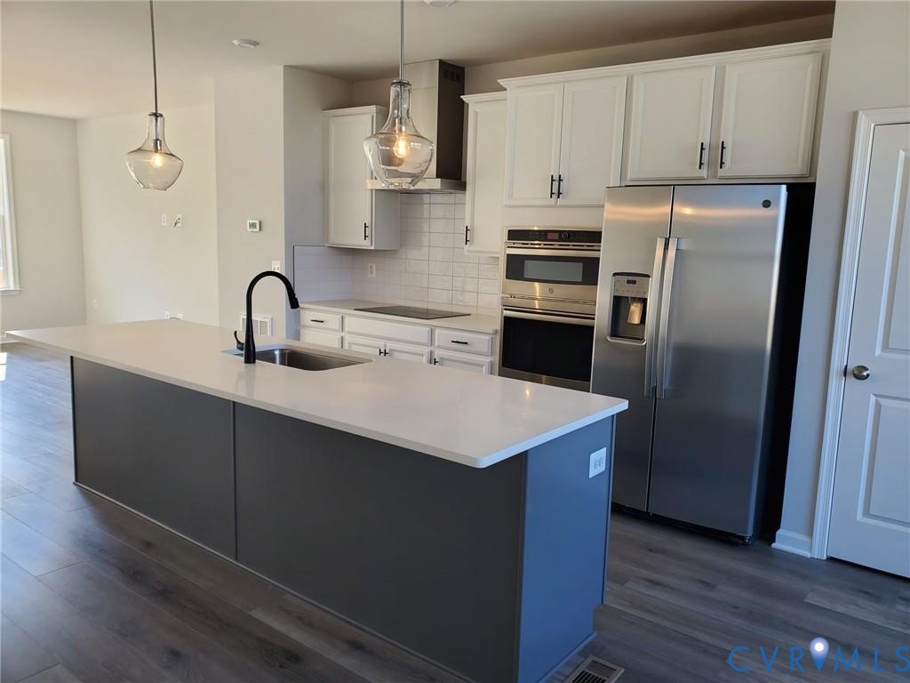 8833 Foxway Ridge Lane Glen Allen, VA 23060 - Photo 9 of 27 a kitchen with kitchen island stainless steel appliances a sink cabinets and wooden floor