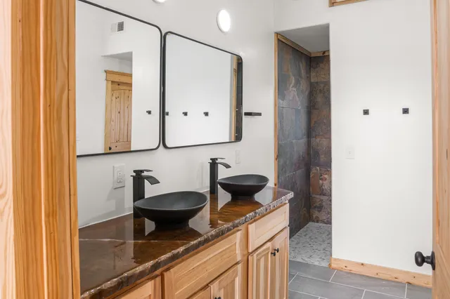 a bathroom with a granite countertop sink a toilet and a shower