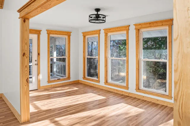 a view of a room that has a large window and front door