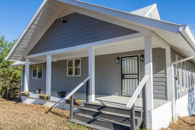 a view of a house with a yard and wooden fence