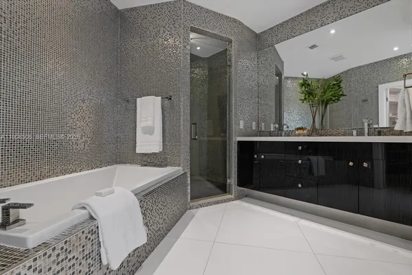 a spacious bathroom with a bathtub sink and mirror