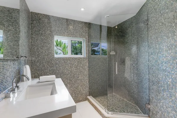 a bathroom with a sink a shower and a mirror