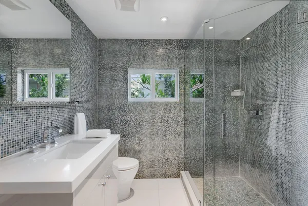 a bathroom with a sink a toilet and shower