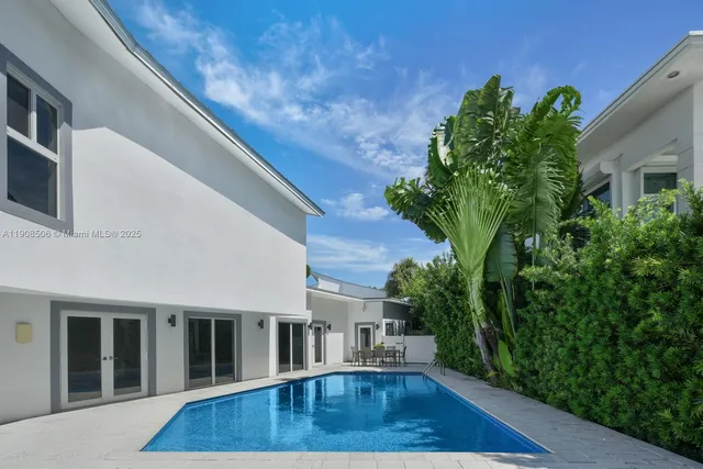 a view of backyard with potted plants and wooden fence