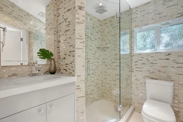 a bathroom with a granite countertop toilet sink and shower