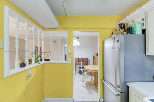 a view of a living room with furniture and a refrigerator