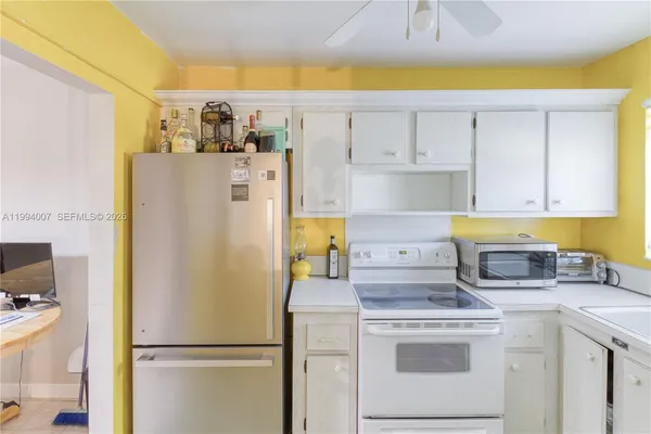 a kitchen with a refrigerator a stove a washer and a dining table