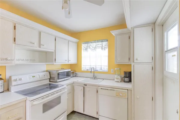 a kitchen with white cabinets and white appliances