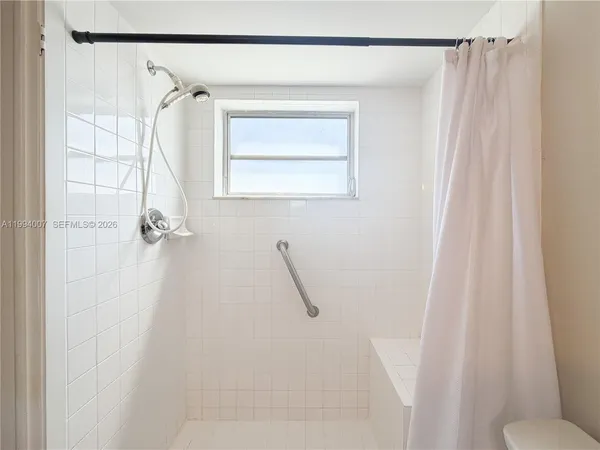 a bathroom with a shower curtain and a window