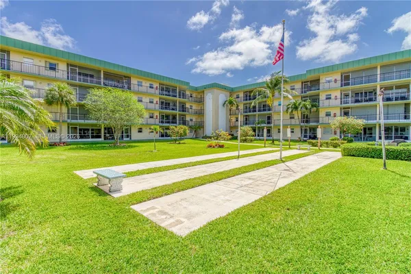 a view of a big building with a big yard and large trees