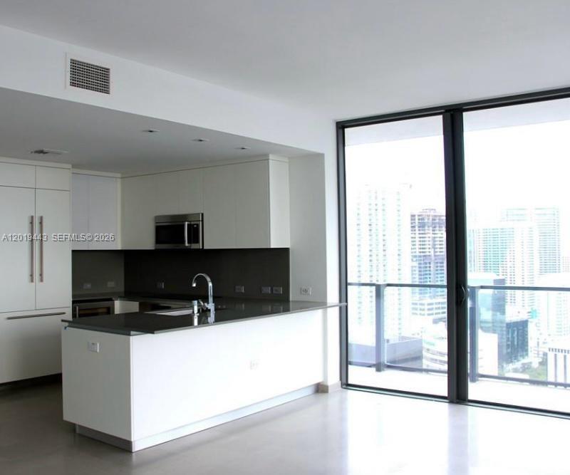 68 Southeast 6th Street, Unit 2702 Miami, FL 33131 - Photo 4 of 28 a kitchen with stainless steel appliances a sink a stove a refrigerator a window