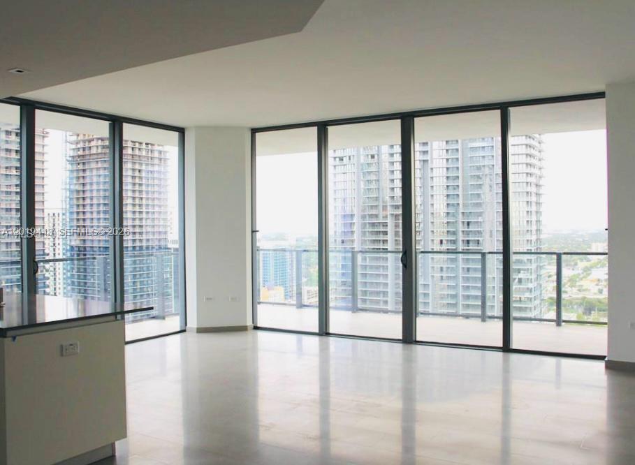68 Southeast 6th Street, Unit 2702 Miami, FL 33131 - Photo 5 of 28 a view of an empty room with wooden floor and a window