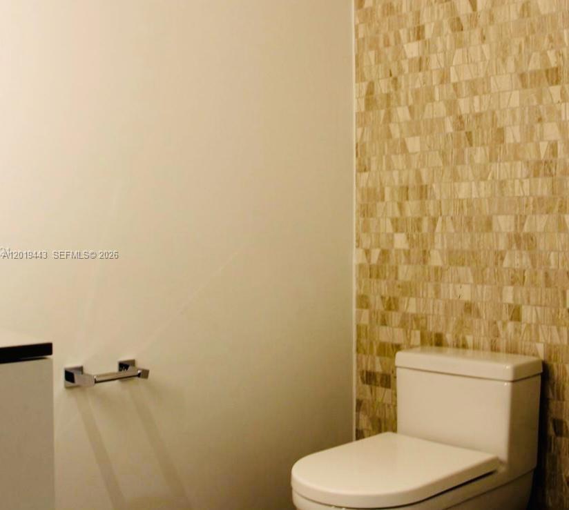 68 Southeast 6th Street, Unit 2702 Miami, FL 33131 - Photo 7 of 28 a white toilet sitting next to a shower curtain