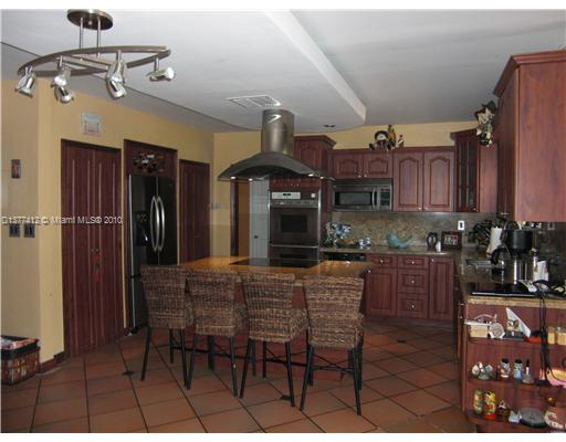 5205 Alton Road Miami Beach, FL 33140 - Photo 10 of 16 a kitchen with stainless steel appliances granite countertop a sink and cabinets